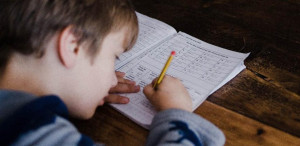 Young child writing what appears to be homework