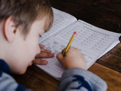 Young child writing what appears to be homework