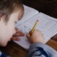 Young child writing what appears to be homework