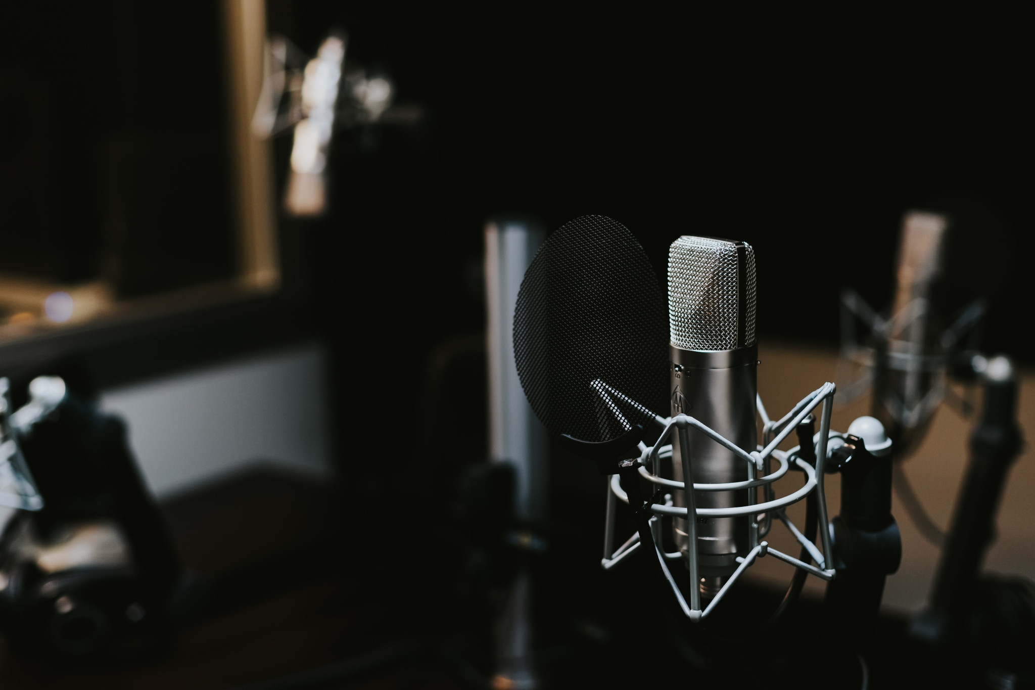 Photo of a recording studio, with microphone in the foreground